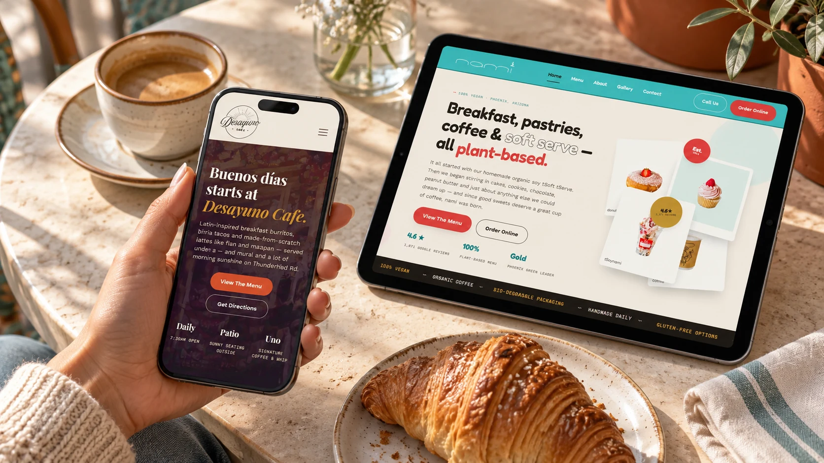 Coffee-shop website concepts shown on a phone and tablet at a café table